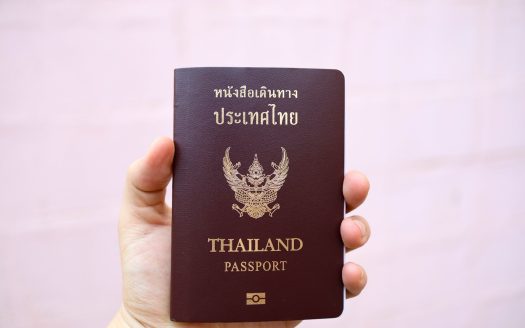 a person holding a thai passport in their hand